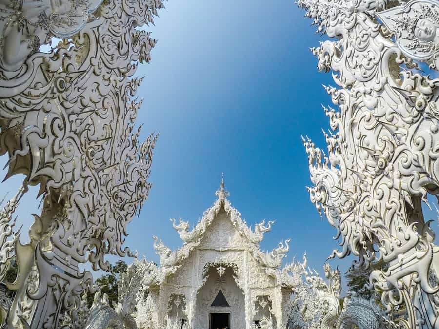 From Chiang Mai: Chiang Rai Guided Day Trip - Wat Rong Suea Ten (Blue Temple): murals, blue interior, and Spanish explanations